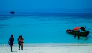 Tourist enjoy a swim in the blue waters of a beach.