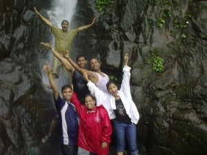 Trekkers  enjoy themselves at a waterfall as they trek the Raigad Fort.
